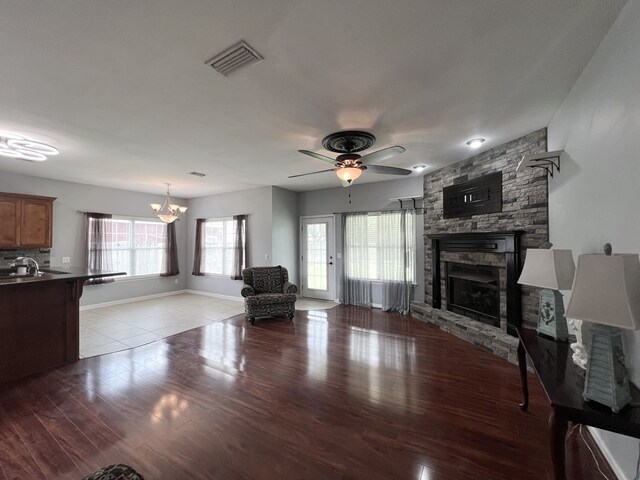 305 Millenia St, Enterprise, AL 36330 - living room with a fireplace, a ceiling fan, a chandelier, wood finished floors, and baseboards