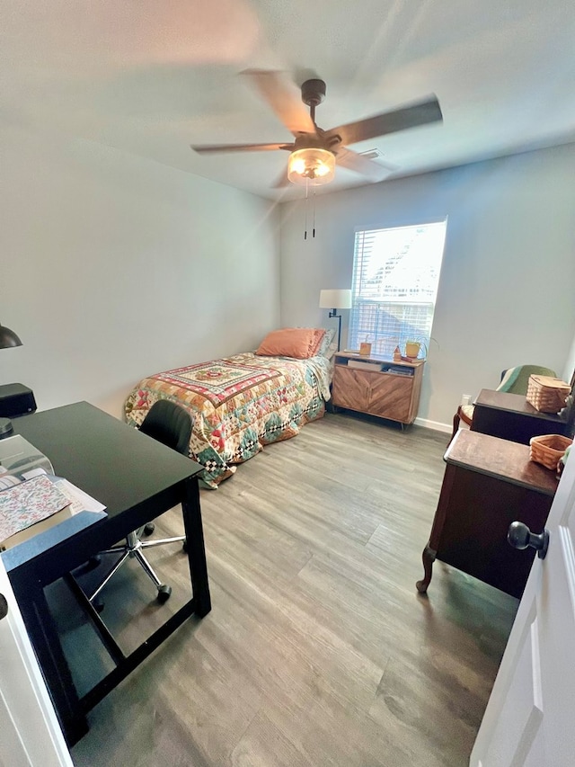 bedroom featuring light wood-style flooring, baseboards, and ceiling fan