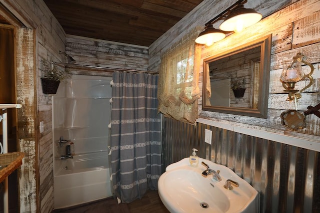 bathroom with wood ceiling, wood walls, sink, and shower / bath combination with curtain