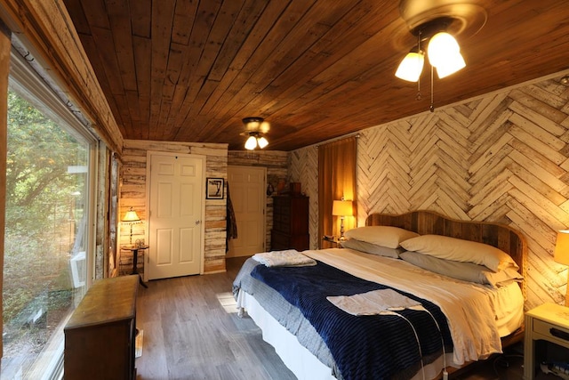 bedroom with access to exterior, wooden walls, wood ceiling, and dark hardwood / wood-style floors