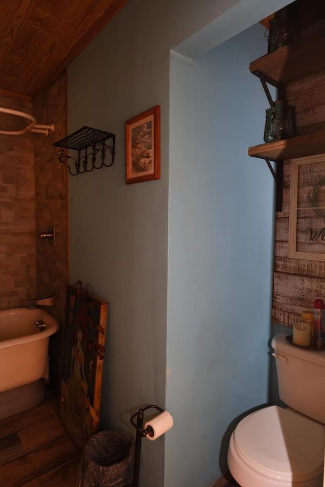 bathroom featuring hardwood / wood-style flooring, toilet, wooden ceiling, and a bath