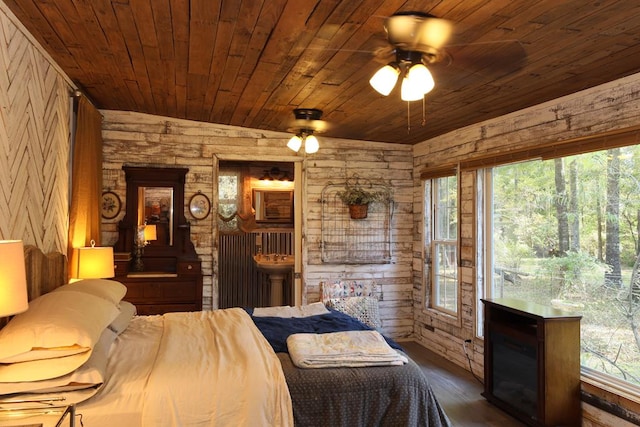 bedroom featuring wood walls, ceiling fan, dark hardwood / wood-style floors, and wood ceiling