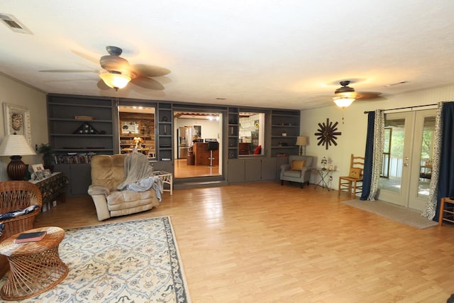 living room featuring hardwood / wood-style flooring, ceiling fan, built in features, and french doors