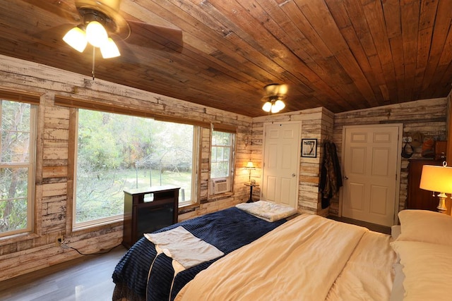 bedroom with ceiling fan, wood-type flooring, wood ceiling, and multiple windows