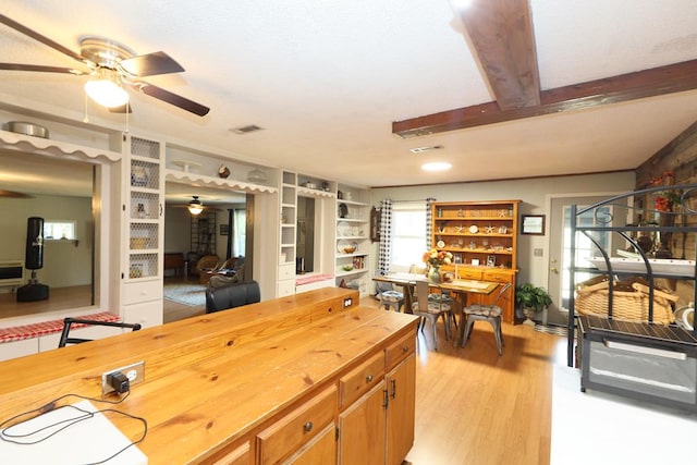 kitchen featuring wood counters, beam ceiling, light hardwood / wood-style flooring, and built in features