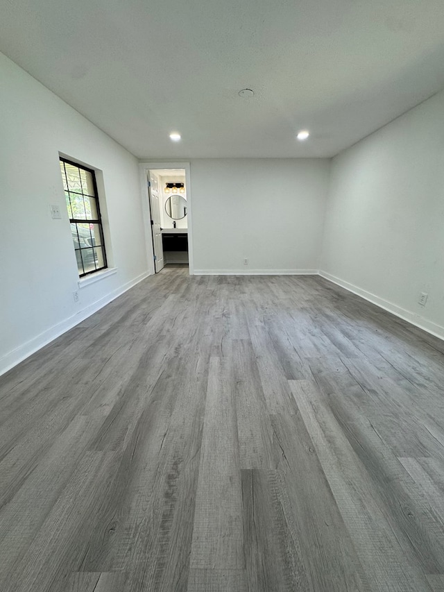 unfurnished living room featuring recessed lighting, dark wood finished floors, and baseboards