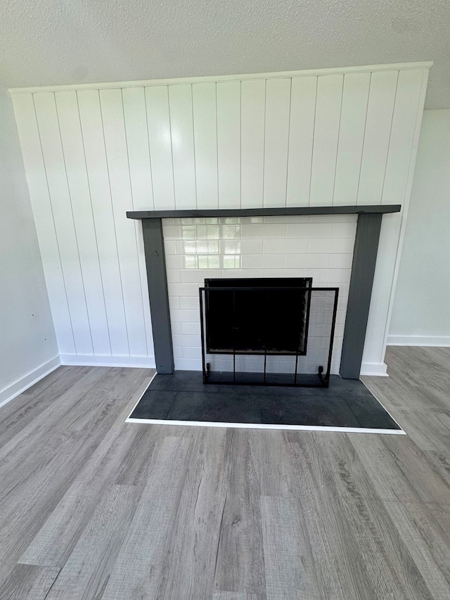 interior details with baseboards, a fireplace, and wood finished floors