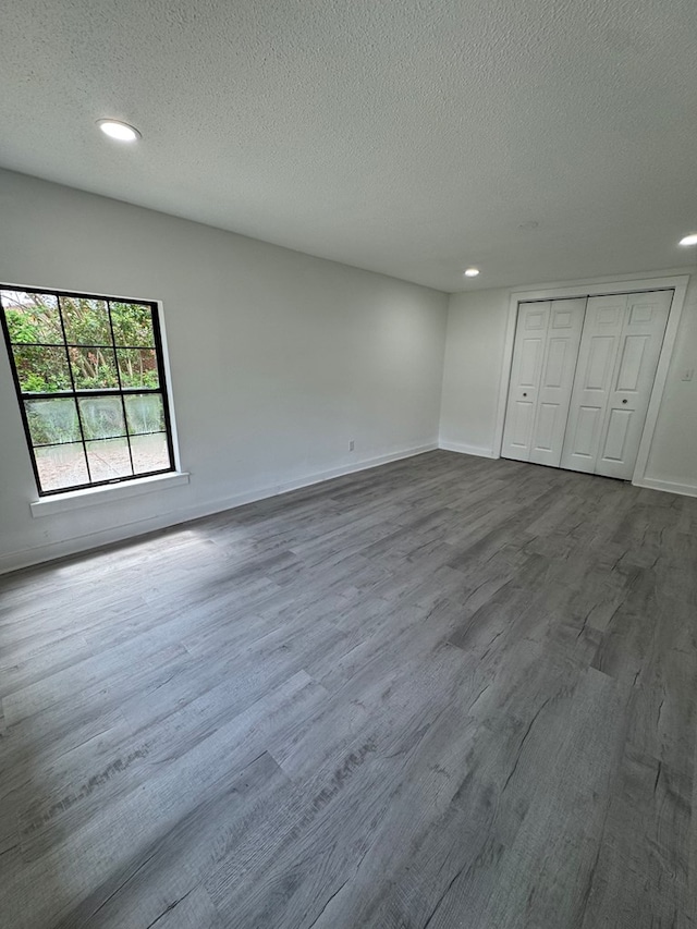 unfurnished bedroom featuring recessed lighting, a textured ceiling, and dark wood-style floors