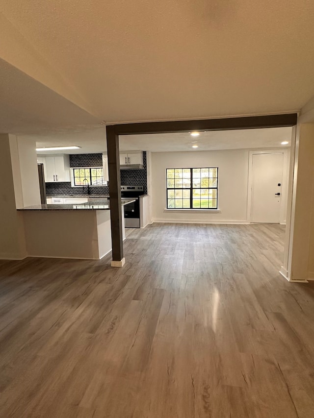 unfurnished living room with baseboards and wood finished floors