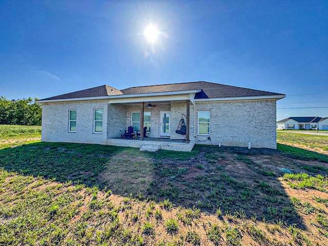 back of property with a yard, ceiling fan, a patio area, and brick siding