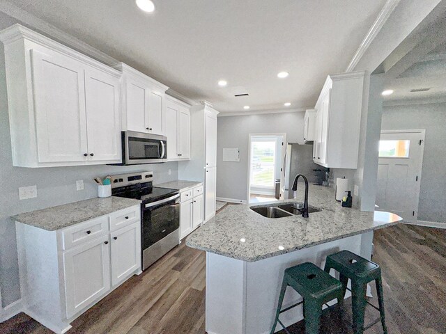 kitchen featuring baseboards, a sink, appliances with stainless steel finishes, dark wood-style floors, and white cabinetry