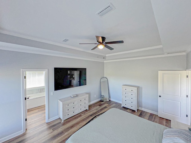 bedroom featuring visible vents, baseboards, ornamental molding, and wood finished floors