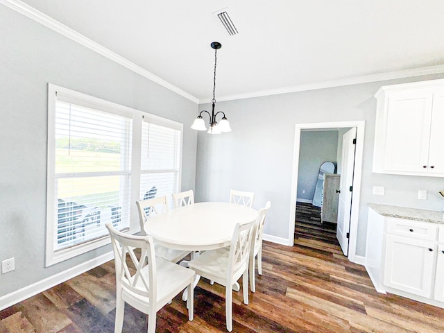 dining room with crown molding, visible vents, a chandelier, wood finished floors, and baseboards