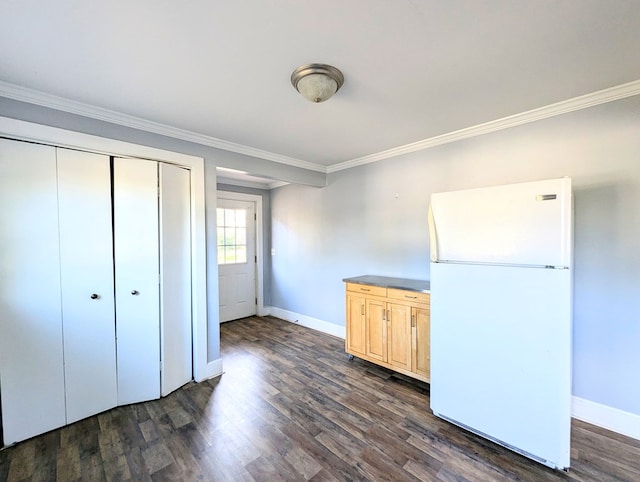 unfurnished bedroom featuring white fridge, dark hardwood / wood-style flooring, crown molding, and a closet