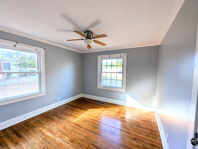 spare room featuring a wealth of natural light, crown molding, and hardwood / wood-style flooring