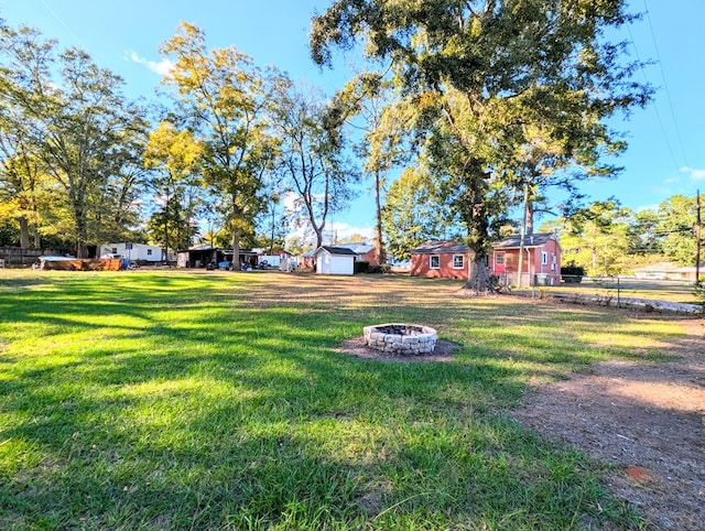 view of yard with a shed and an outdoor fire pit