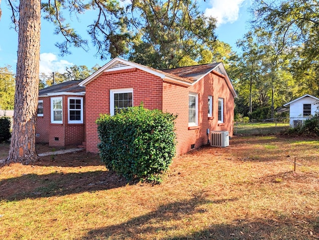 view of side of home featuring central AC and a yard