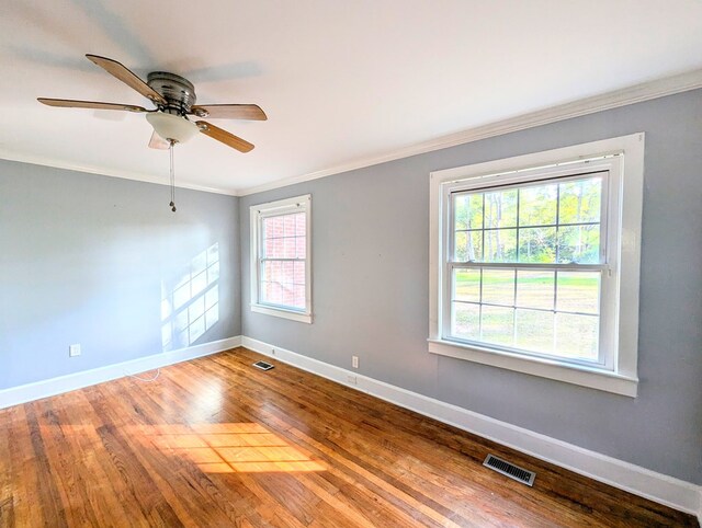 spare room featuring ornamental molding, hardwood / wood-style flooring, ceiling fan, and a healthy amount of sunlight