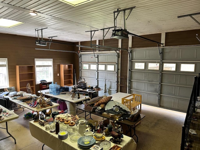 garage with wood walls and a garage door opener