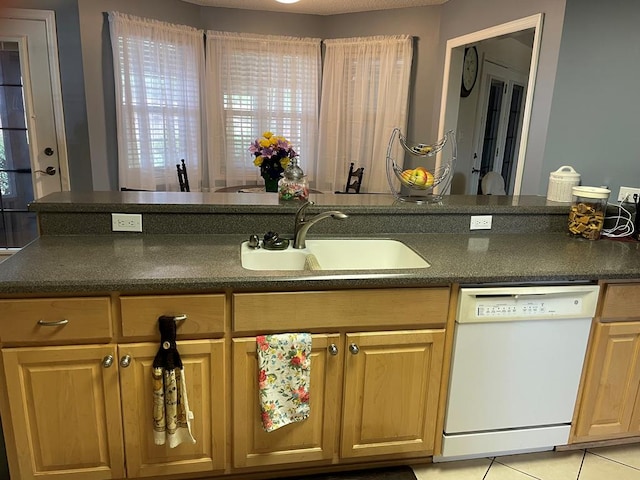 kitchen with sink, white dishwasher, and light tile patterned flooring