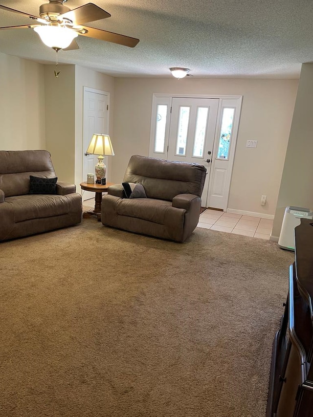 living room with ceiling fan, light colored carpet, and a textured ceiling