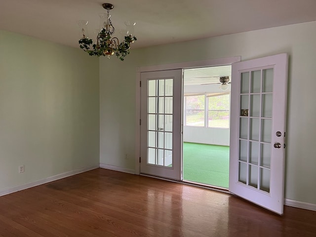 entryway featuring baseboards, wood finished floors, french doors, and a chandelier