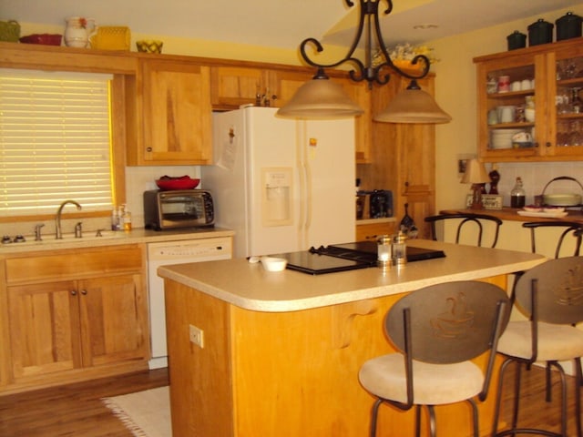 kitchen featuring sink, a center island, hanging light fixtures, a notable chandelier, and white appliances