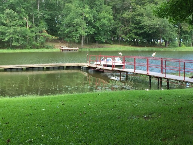 dock area featuring a water view and a yard