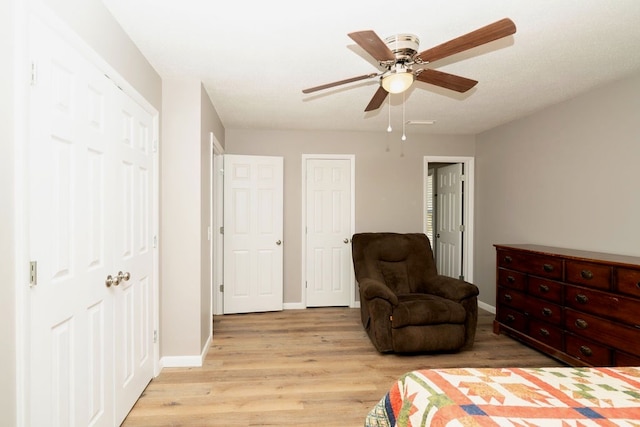 bedroom featuring light wood-style flooring, baseboards, and a ceiling fan