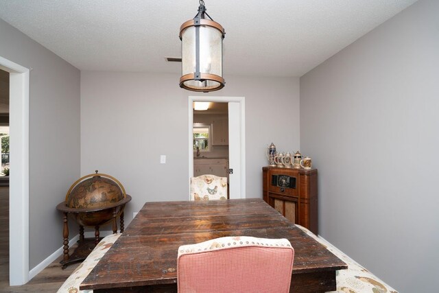 dining space featuring wood finished floors, baseboards, and visible vents