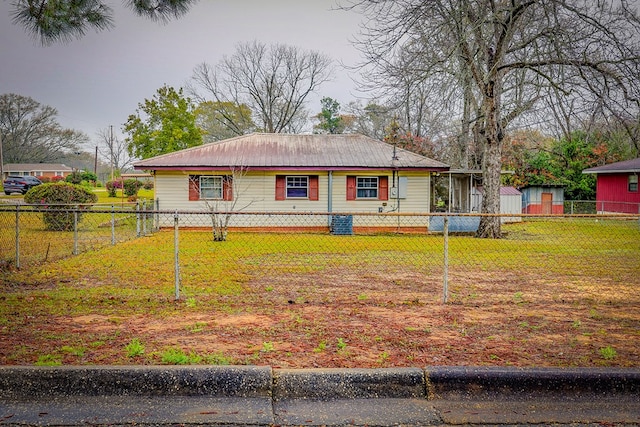 view of front of home featuring a front yard, a storage unit, a fenced backyard, and an outdoor structure