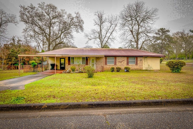 view of front of home with fence, aphalt driveway, a front yard, metal roof, and a carport