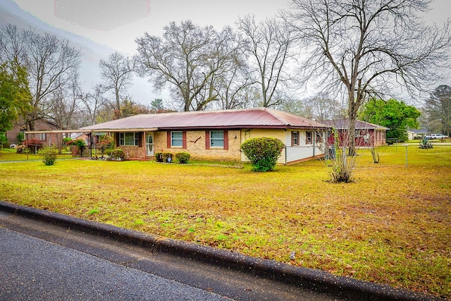 ranch-style house with metal roof and a front yard