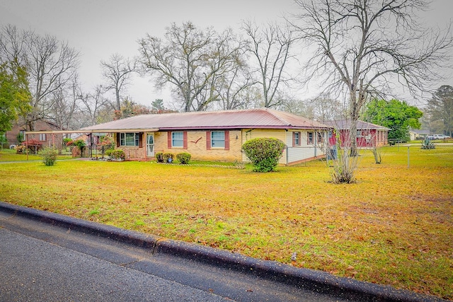 single story home featuring metal roof and a front lawn