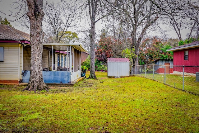 view of yard featuring a shed, an outdoor structure, and fence