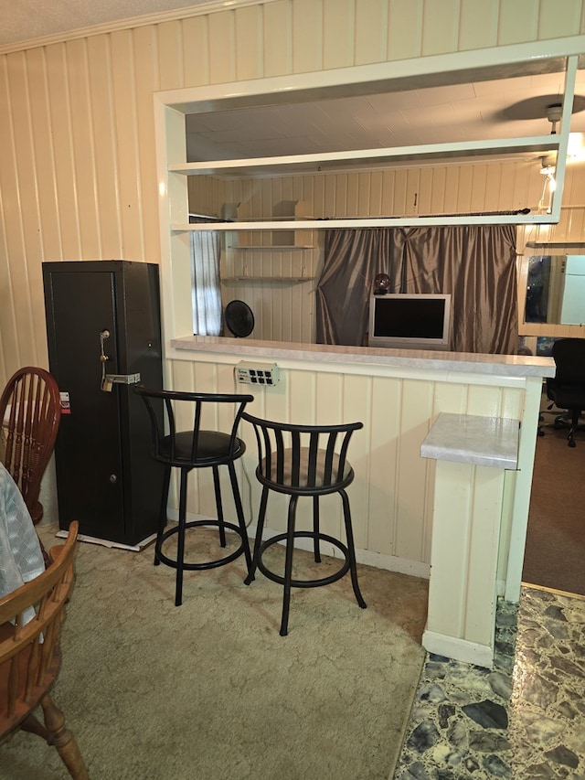 kitchen with light carpet, kitchen peninsula, and white cabinets