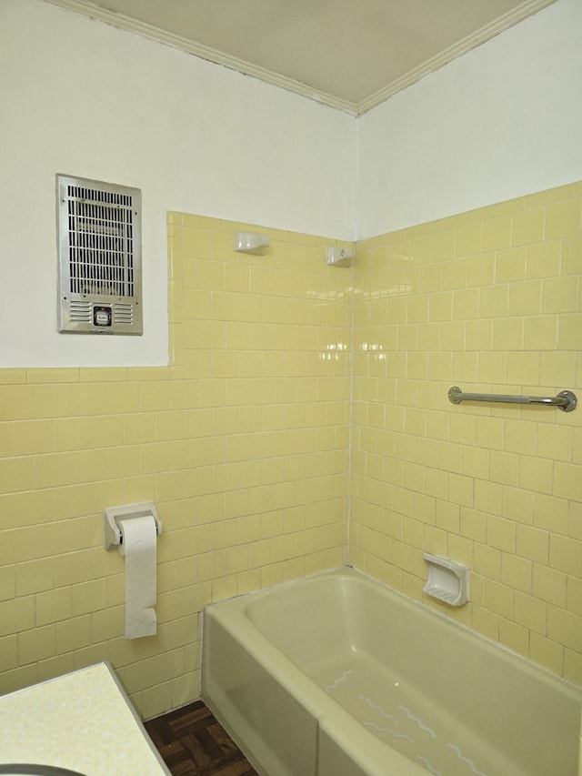 bathroom with crown molding, parquet floors, tiled shower / bath combo, and tile walls