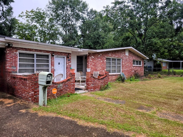 ranch-style home featuring a front lawn