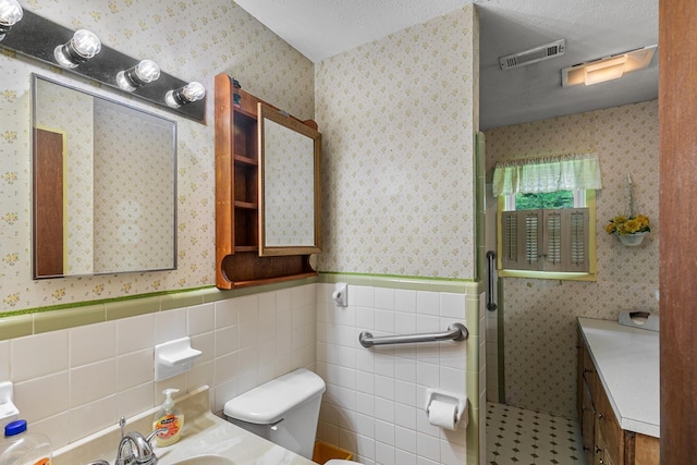 155 Sharon Ln, Ozark, AL 36360 - full bath with toilet, vanity, a wainscoted wall, a shower stall, and tile walls