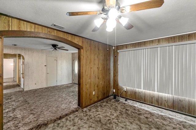 155 Sharon Ln, Ozark, AL 36360 - carpeted empty room with arched walkways, ceiling fan, and wooden walls