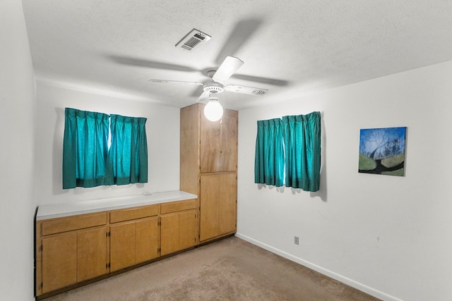 155 Sharon Ln, Ozark, AL 36360 - unfurnished bedroom featuring light colored carpet, baseboards, a textured ceiling, and a ceiling fan
