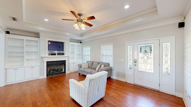 living room featuring a raised ceiling and hardwood / wood-style floors