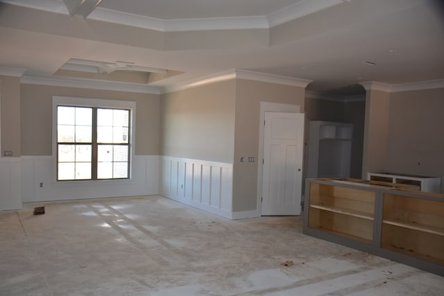 empty room featuring a raised ceiling and ornamental molding