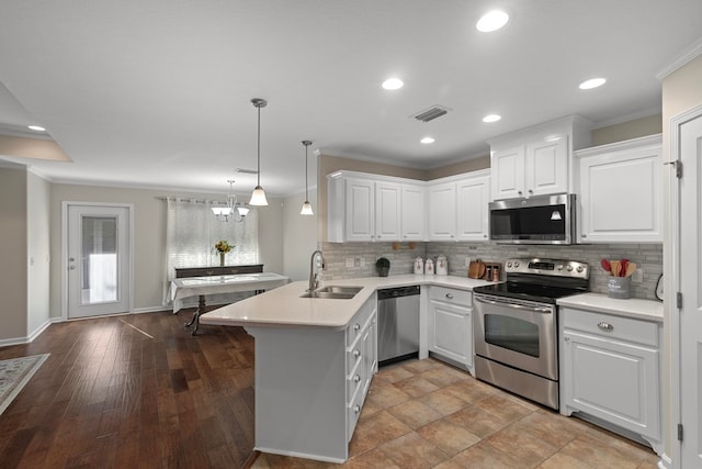 kitchen featuring white cabinets, kitchen peninsula, stainless steel appliances, and hardwood / wood-style flooring