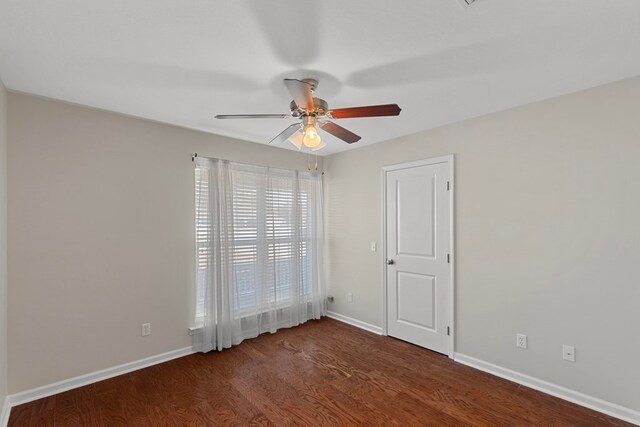 empty room with dark hardwood / wood-style flooring and ceiling fan