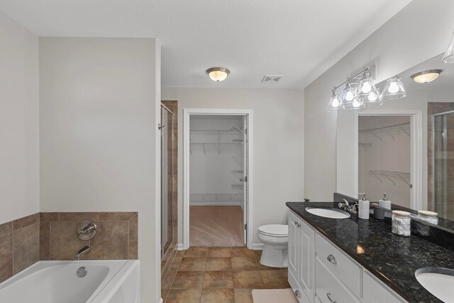 full bathroom with plus walk in shower, vanity, toilet, and tile patterned flooring