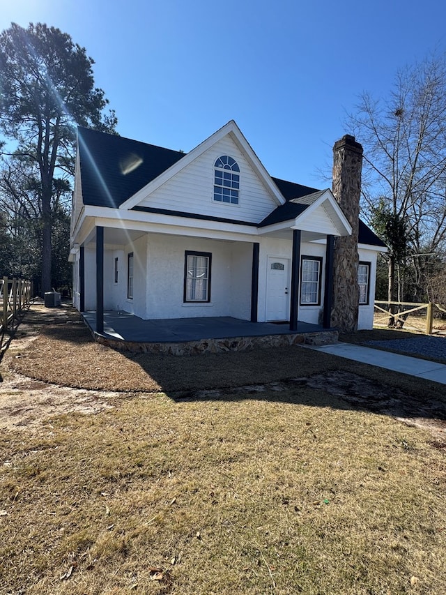 view of front of house featuring covered porch and a front lawn