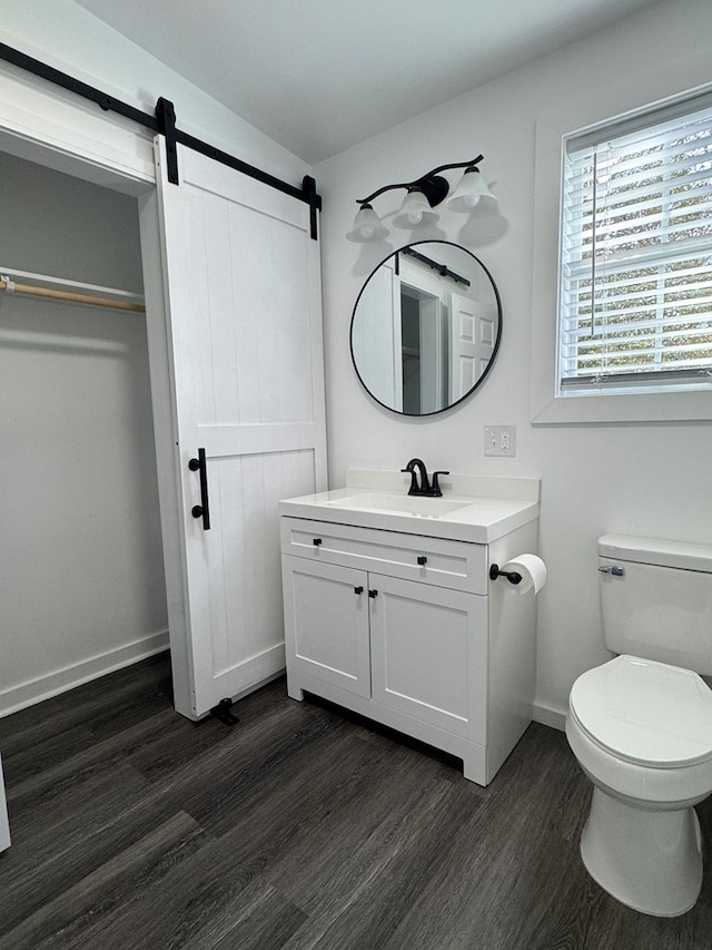 bathroom with hardwood / wood-style flooring, vanity, and toilet