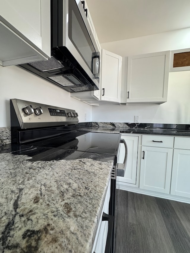 kitchen with stainless steel appliances, white cabinetry, dark hardwood / wood-style floors, and light stone counters