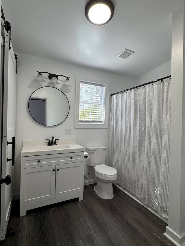 bathroom featuring vanity, hardwood / wood-style flooring, and toilet